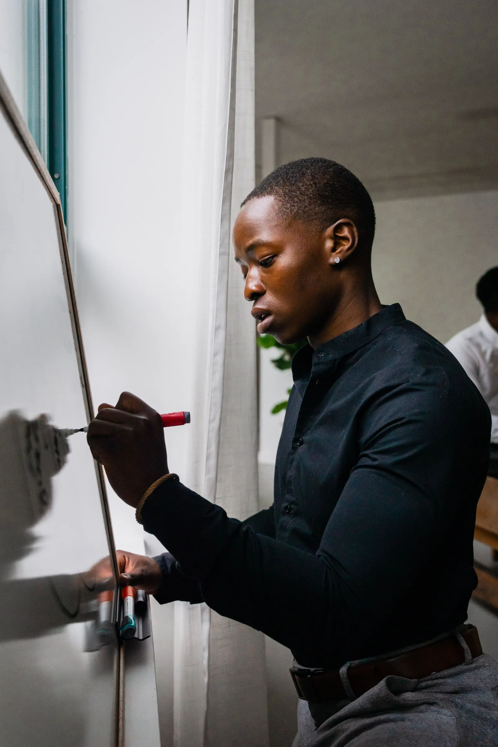A facilitator writing on a whiteboard